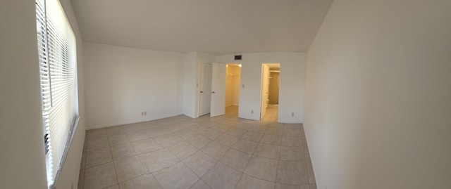 unfurnished bedroom featuring baseboards, light tile patterned floors, a spacious closet, and visible vents
