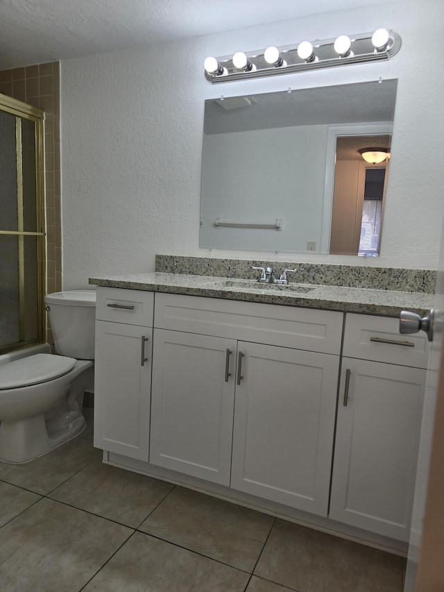 full bathroom with tile patterned flooring, a textured wall, and a shower with door