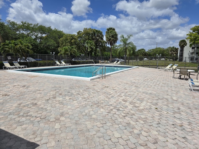 community pool featuring fence and a patio