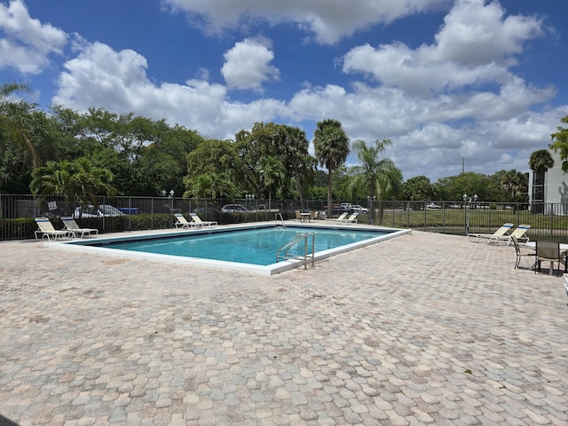 pool featuring fence and a patio