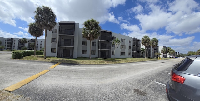 view of property featuring a residential view and uncovered parking