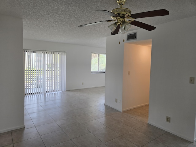 unfurnished room featuring visible vents, a ceiling fan, a textured ceiling, and tile patterned floors