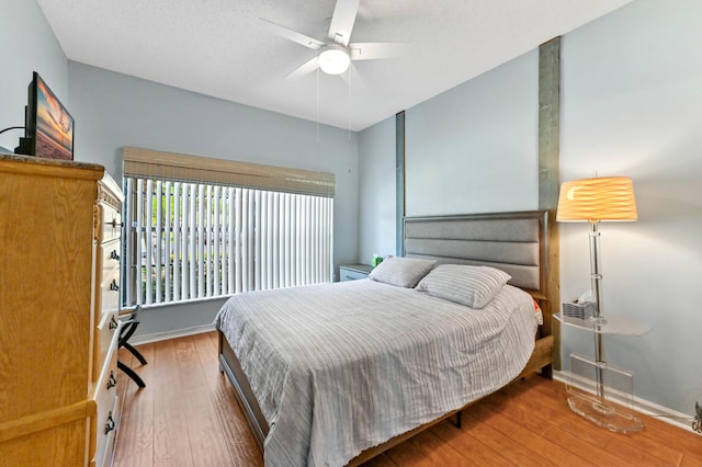 bedroom with baseboards, ceiling fan, and wood-type flooring