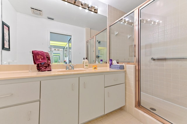 bathroom featuring tile patterned floors, vanity, a stall shower, and visible vents