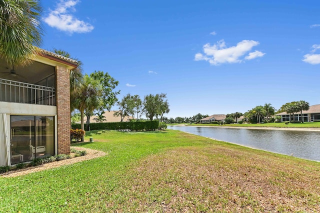 view of yard featuring a ceiling fan and a water view
