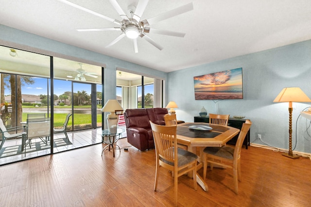 dining space featuring a ceiling fan, baseboards, and wood finished floors