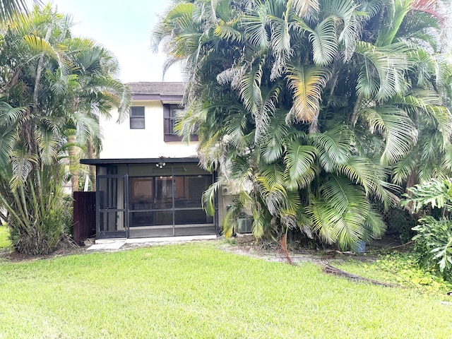 3779 Carambola Cir N Unit 28102, Coconut Creek, FL 33066 - rear view of house with a sunroom, a lawn, and stucco siding