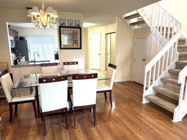 3779 Carambola Cir N Unit 28102, Coconut Creek, FL 33066 - dining area with a chandelier, wood finished floors, and stairway