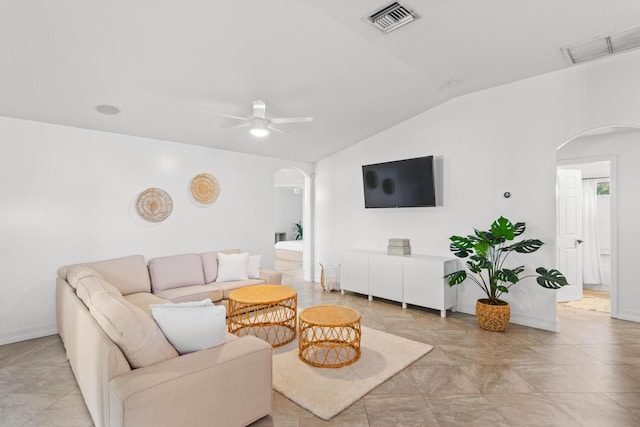living room with arched walkways, vaulted ceiling, a ceiling fan, and baseboards