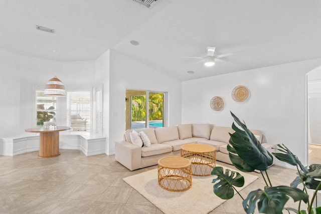 living area featuring lofted ceiling and a ceiling fan