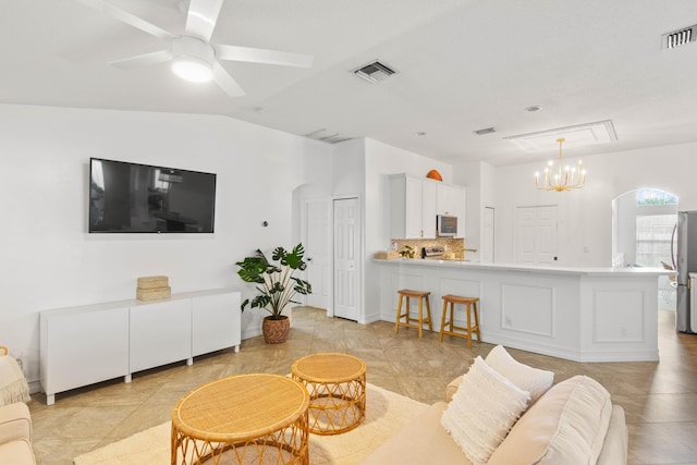 living area featuring a chandelier, light tile patterned floors, vaulted ceiling, and a ceiling fan