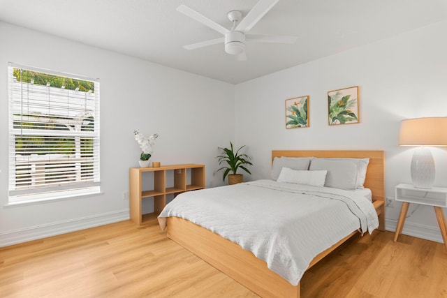 bedroom featuring wood finished floors, baseboards, and ceiling fan