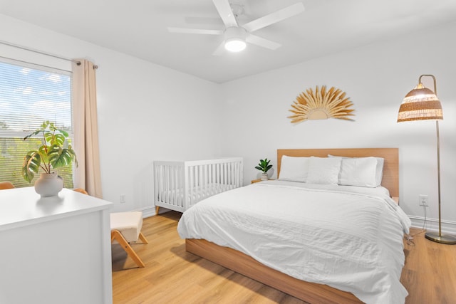 bedroom featuring light wood finished floors, baseboards, and a ceiling fan