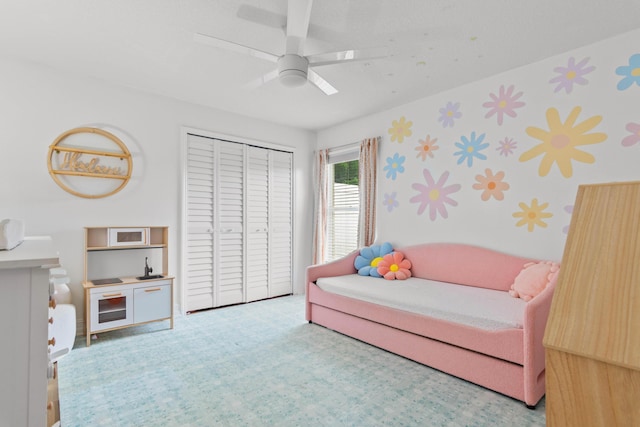 bedroom with wallpapered walls, carpet, a closet, and a ceiling fan