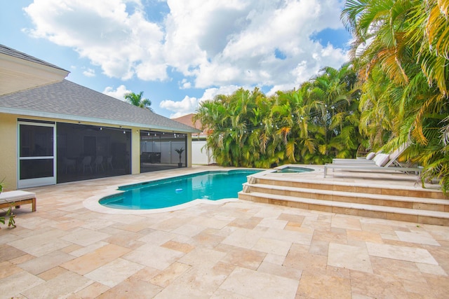 view of pool featuring a sunroom, a patio, and an in-ground hot tub