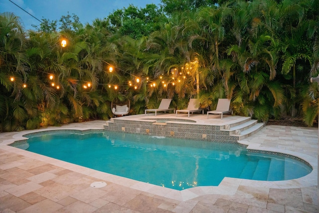 outdoor pool with an in-ground hot tub and a patio