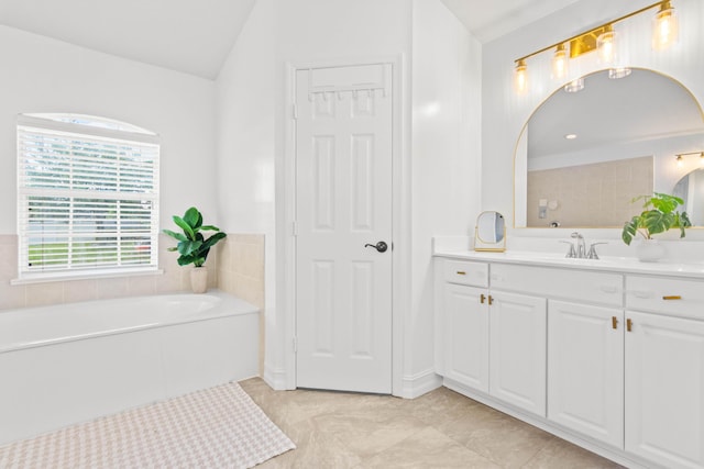 bathroom with vaulted ceiling, a garden tub, and vanity
