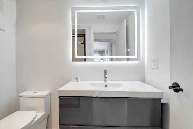 373 Piedmont H, Delray Beach, FL 33484 - half bathroom with visible vents, toilet, and vanity