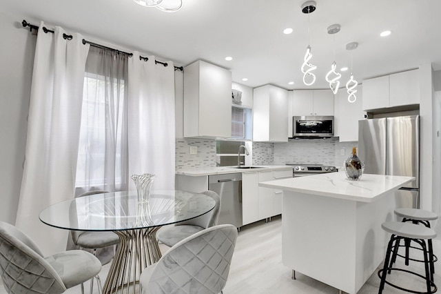 373 Piedmont H, Delray Beach, FL 33484 - kitchen featuring a sink, backsplash, appliances with stainless steel finishes, and a kitchen island