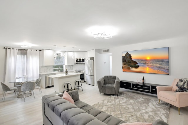 373 Piedmont H, Delray Beach, FL 33484 - living area featuring light wood finished floors and visible vents