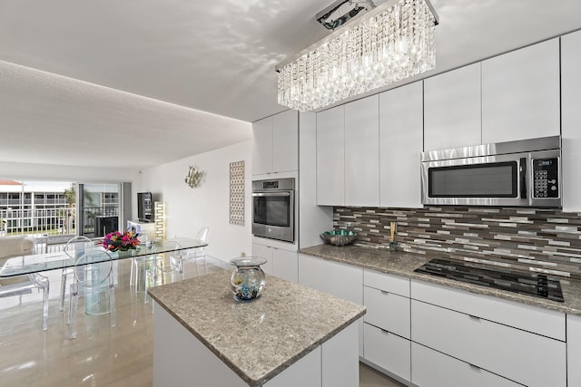 kitchen featuring white cabinetry, a kitchen island, appliances with stainless steel finishes, and tasteful backsplash