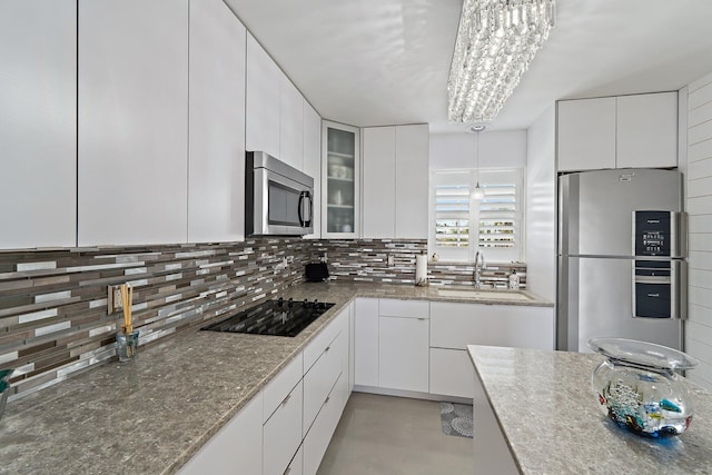 kitchen with appliances with stainless steel finishes, tasteful backsplash, and white cabinets