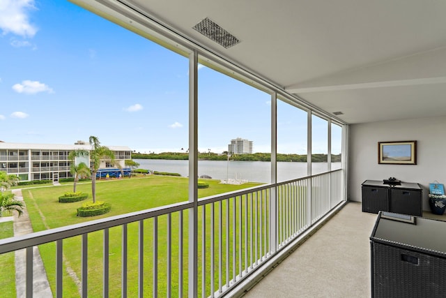 sunroom / solarium with a water view and visible vents