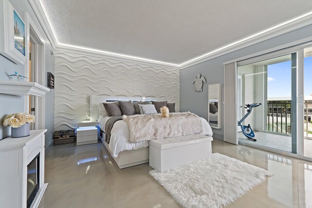 bedroom with concrete floors, access to exterior, and a textured ceiling