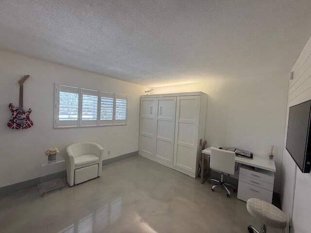 office area featuring a textured ceiling and finished concrete floors