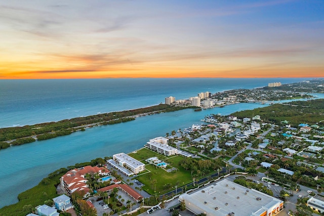 aerial view at dusk featuring a water view