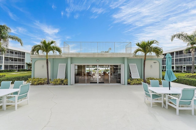 back of house featuring stucco siding, a patio, and outdoor dining area