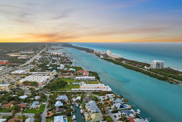 aerial view at dusk featuring a water view