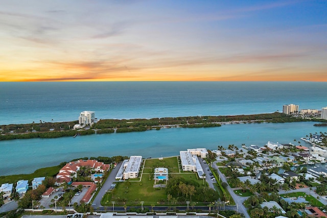 aerial view at dusk featuring a water view