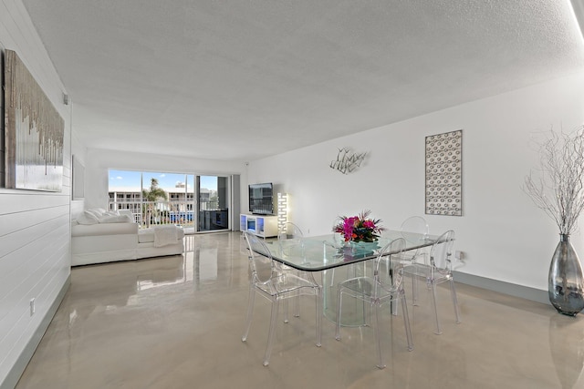 dining area featuring a textured ceiling and finished concrete flooring