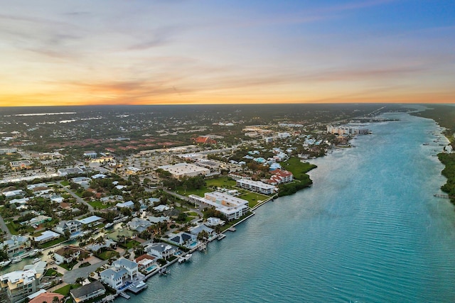 aerial view at dusk featuring a water view