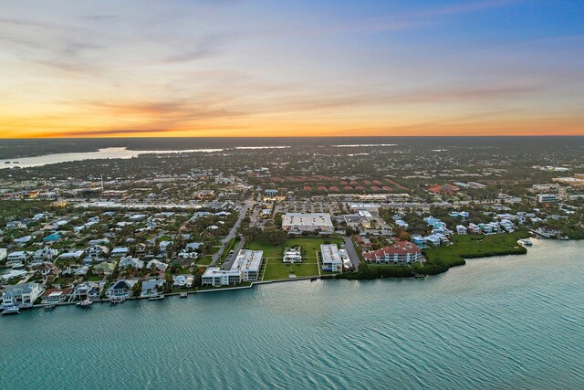 aerial view at dusk featuring a water view