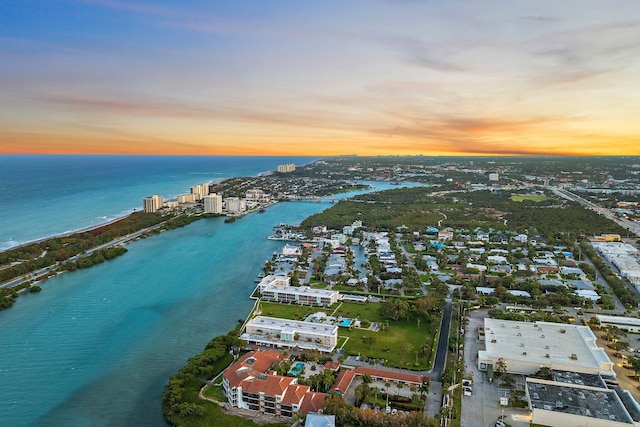 aerial view at dusk featuring a water view