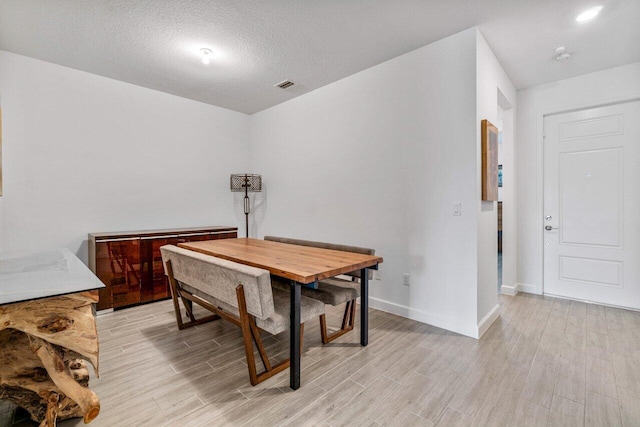 7113 Peters Ln, Delray Beach, FL 33446 - dining room with baseboards, a textured ceiling, visible vents, and light wood-style floors