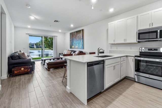 7113 Peters Ln, Delray Beach, FL 33446 - kitchen featuring open floor plan, visible vents, a sink, and stainless steel appliances