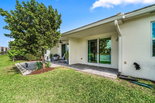 7113 Peters Ln, Delray Beach, FL 33446 - rear view of property featuring stucco siding, a ceiling fan, a yard, and a patio area