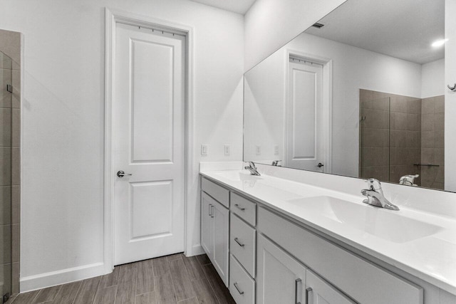 7113 Peters Ln, Delray Beach, FL 33446 - bathroom with double vanity, wood finished floors, tiled shower, and a sink