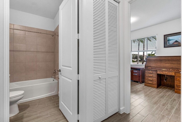 7113 Peters Ln, Delray Beach, FL 33446 - bathroom featuring a closet, wood tiled floor, toilet, and shower / washtub combination