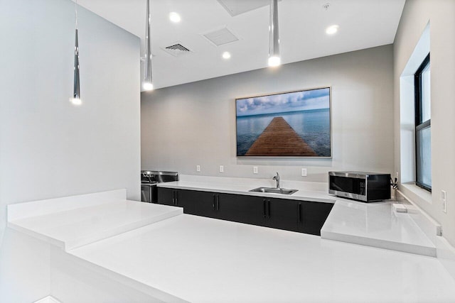 7113 Peters Ln, Delray Beach, FL 33446 - kitchen featuring recessed lighting, stainless steel microwave, a sink, visible vents, and dark cabinets