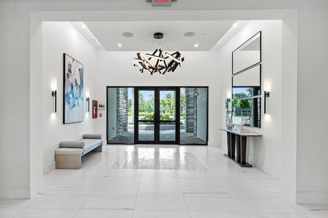 7113 Peters Ln, Delray Beach, FL 33446 - entrance foyer featuring baseboards, french doors, an inviting chandelier, and a towering ceiling
