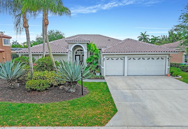 mediterranean / spanish-style home featuring a tiled roof, concrete driveway, stucco siding, and a garage
