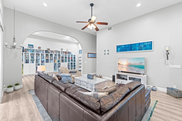 living room featuring recessed lighting, arched walkways, light wood finished floors, and ceiling fan