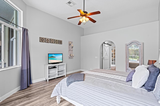 bedroom with wood finished floors, baseboards, a ceiling fan, and visible vents