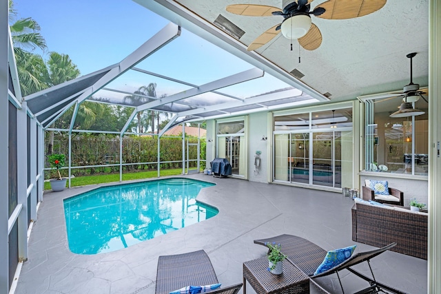 pool featuring a patio, glass enclosure, and a ceiling fan