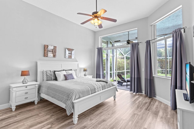 bedroom with light wood finished floors, access to outside, and multiple windows