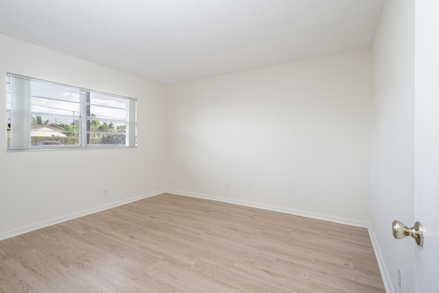 230 NE 26th Ave Unit 1030, Boynton Beach, FL 33435 - unfurnished room featuring baseboards, a textured ceiling, and light wood-style flooring